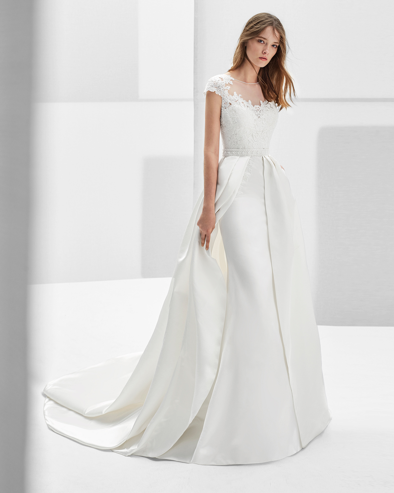 Classic-style duchess satin and guipure lace wedding dress with short sleeves and lace back with beadwork detail, in ivory.
