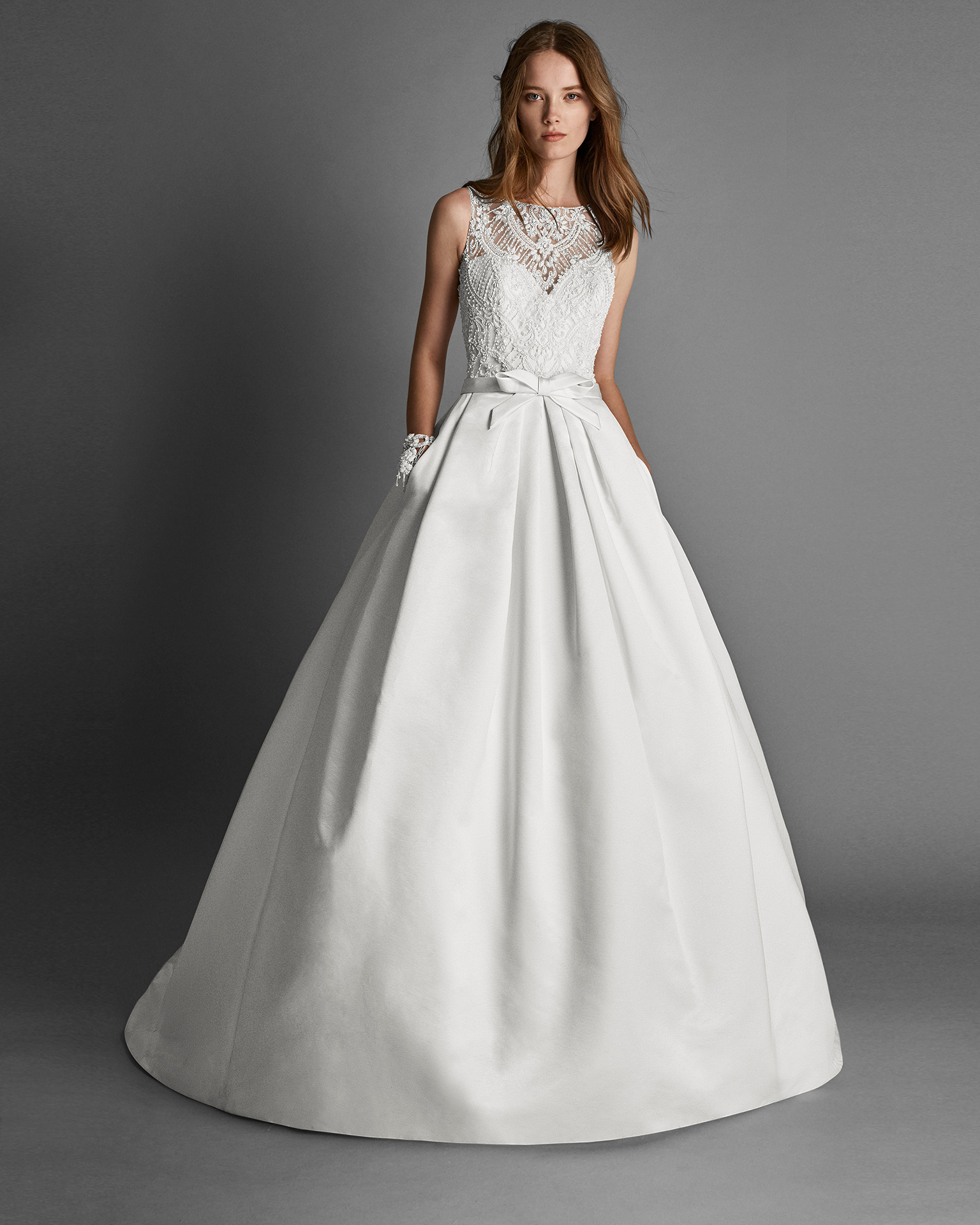 Classic-style beaded lace and duchess satin wedding dress with halter neckline, beaded embroidery back and pockets, in ivory.