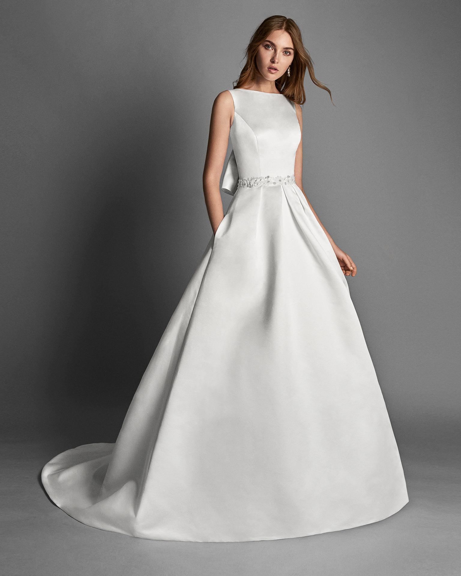 Classic-style beaded lace and duchess satin wedding dress with pockets and jewelled back, in ivory.