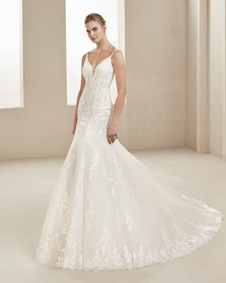 Mermaid-style beaded lace wedding dress. With deep-plunge neckline, straps and low back. Available in natural. 2019 ALMA_NOVIA Collection.