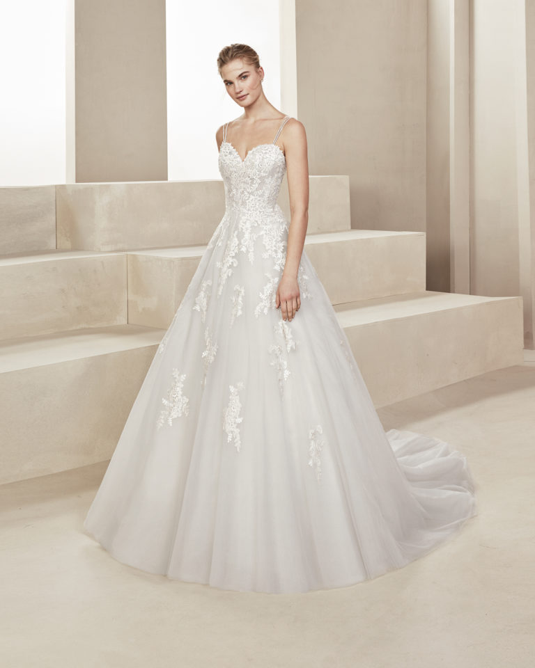 Romantic tulle and lace wedding dress. With sweetheart neckline and beaded straps. Skirt with lace appliqués. Available in ice/silver, amber/silver and natural. 2019 ALMA_NOVIA Collection.