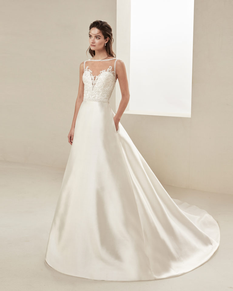 Classic wedding dress in mikado and beaded lace. With illusion neckline and low back. Available in natural. 2019 ALMA_NOVIA Collection.
