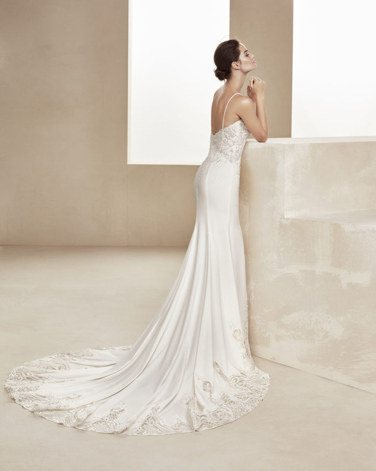 Beaded sheath-style wedding dress in crepe and lace. With sweetheart neckline and beaded straps. Available in natural. 2019 ALMANOVIA Collection.