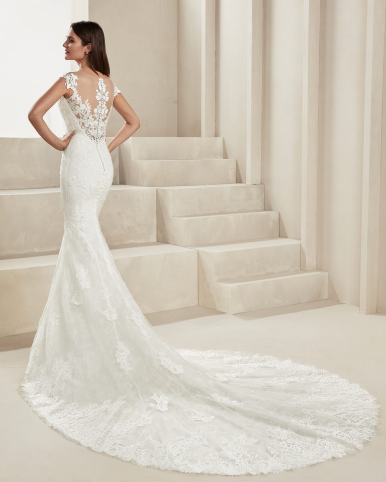 Mermaid-style beaded lace wedding dress. With illusion neckline and lace back. Available in natural. 2019 ALMA_NOVIA Collection.