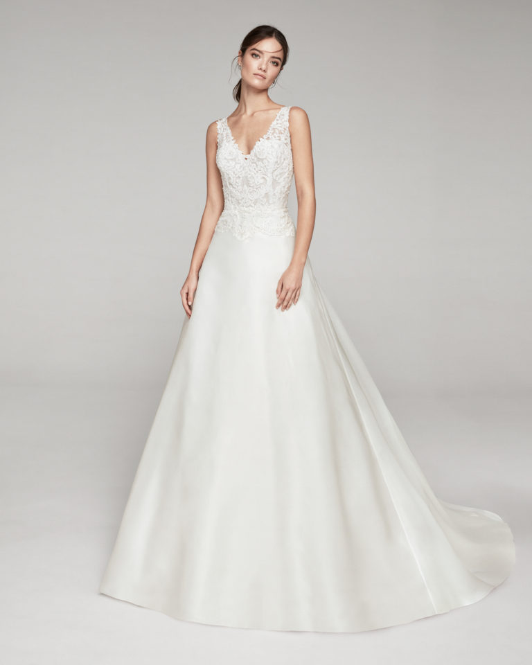 Classic wedding dress in organza and beaded lace. With V-neckline and low back. Available in natural. 2019 ALMANOVIA Collection.
