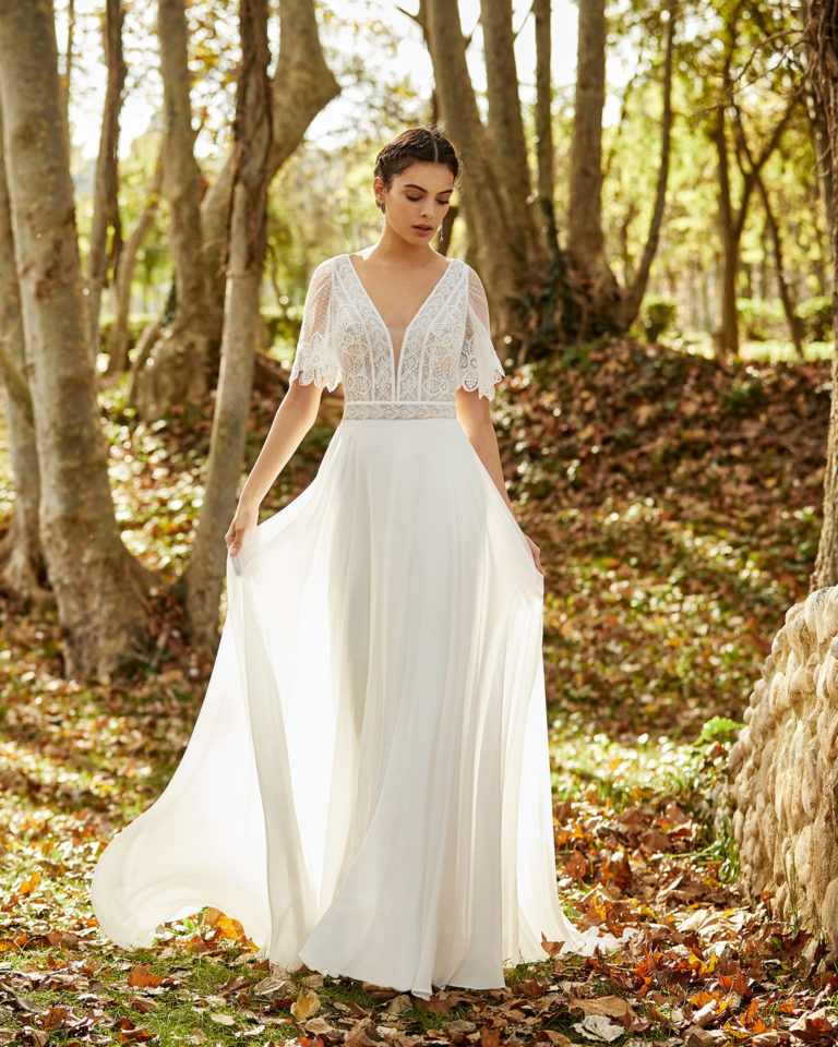 Boho-style lace and chiffon wedding dress with deep-plunge neckline, V-back and short sleeves. 2020 ALMANOVIA Collection.