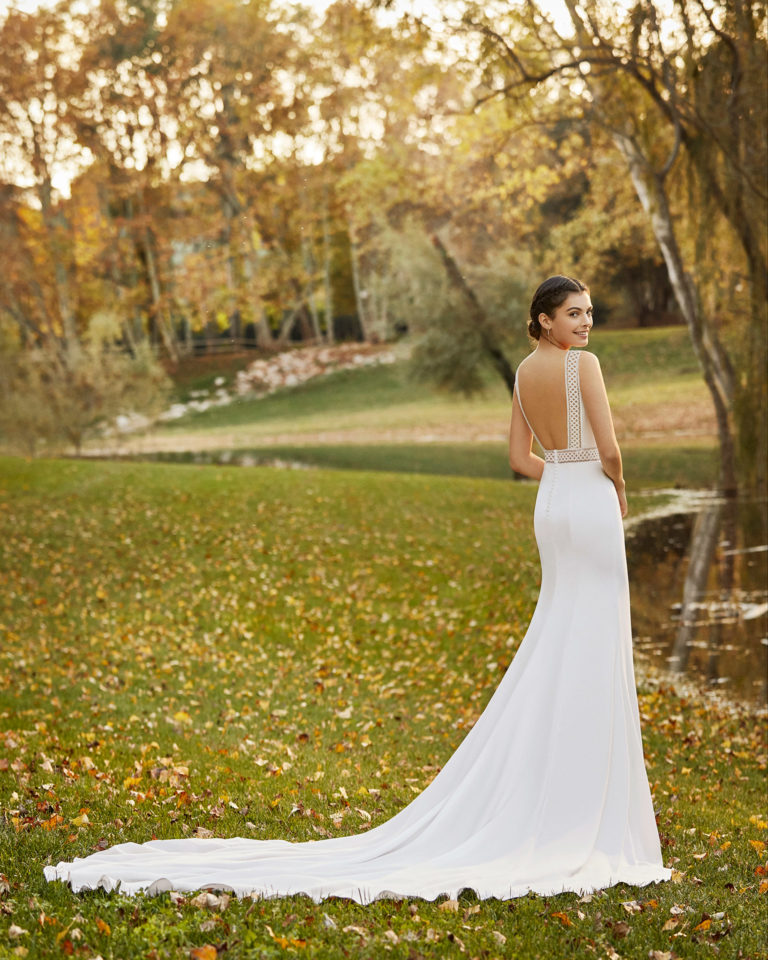 Elegant lace and crepe wedding dress with bateau neckline and low back. 2020 ALMA_NOVIA Collection.