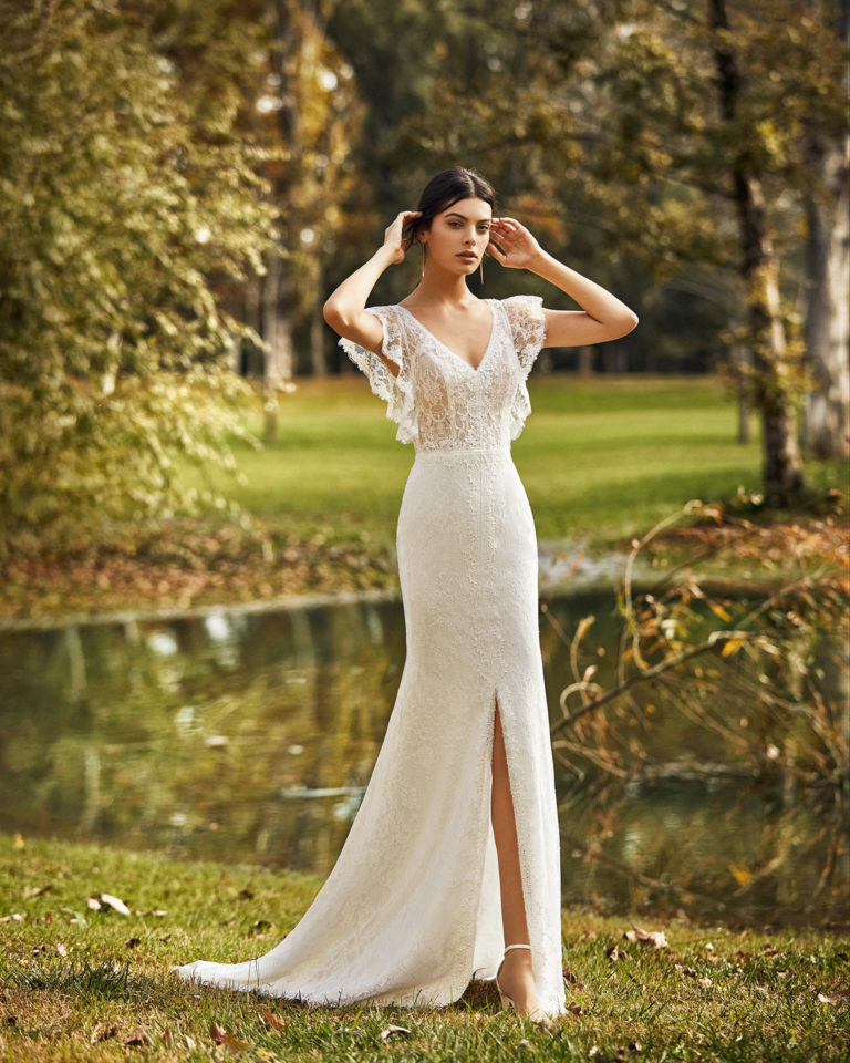 Vestido de novia estilo boho de encaje y pedrería con abertura delantera, con escote en V y espalda cerrada con manga volantes. Colección ALMA_NOVIA 2020.