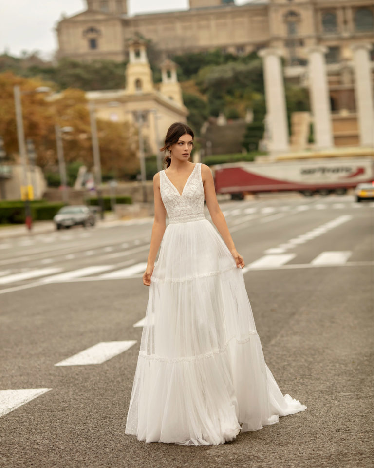 Vestido de novia estilo boho de tul plumeti y encaje, con escote en V y espalda escotada. Colección ALMA_NOVIA 2020.