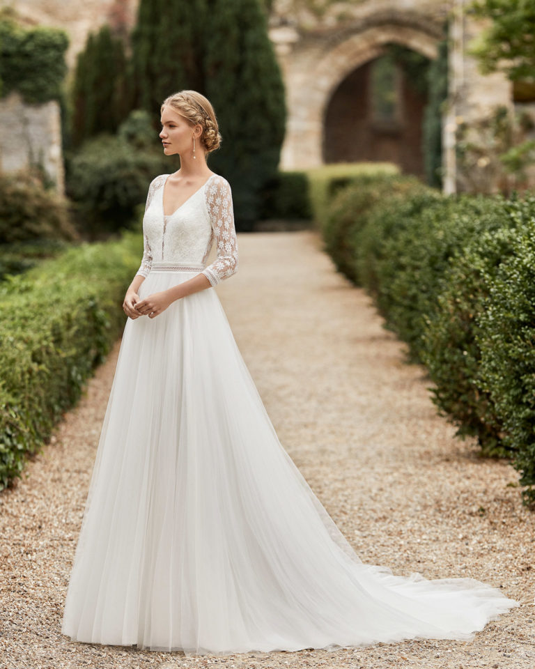 Wedding dress in tulle. V-neckline in lace, three-quarter lace sleeves, lace belt and lace back with buttons. 2021 ALMANOVIA Collection.