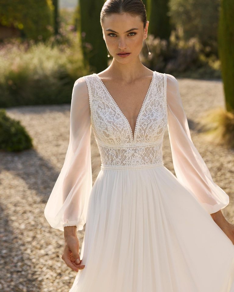 Vestido de novia de silueta recta con escote pico y cuerpo de encaje. Espalda en V, manga larga poeta extraíble y falda de muselina lisa. ALMA_NOVIA.