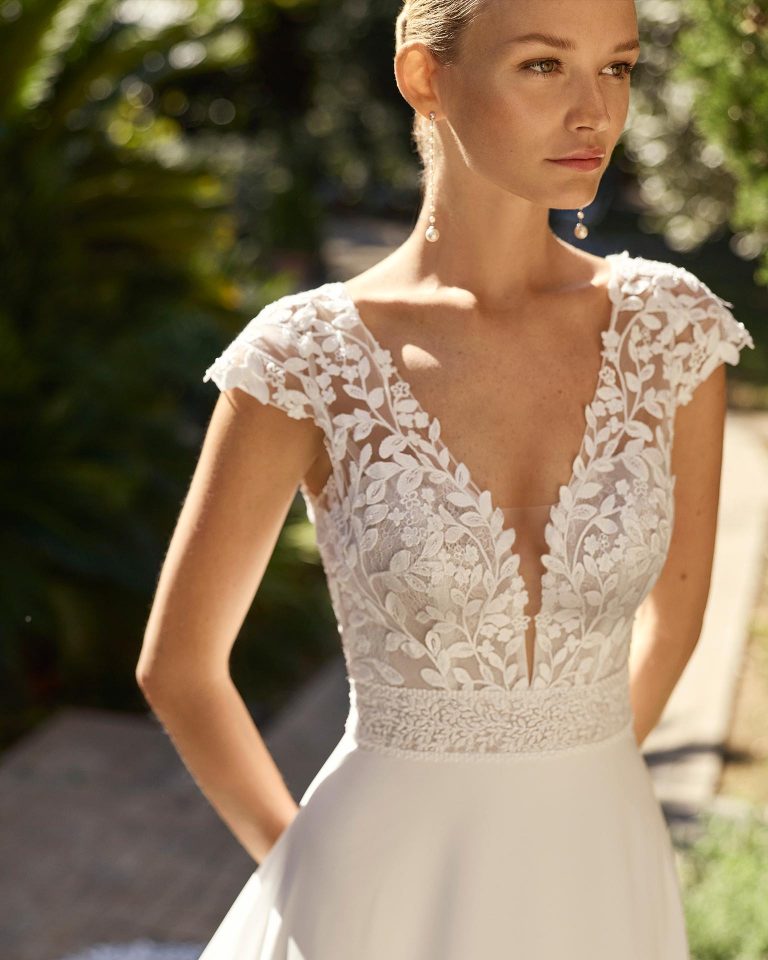 Vestido de novia línea A con escote profundo y manga corta. Cuerpo de encaje, falda de georgette con aplicaciones. Espalda abierta abotonada. ALMA_NOVIA.