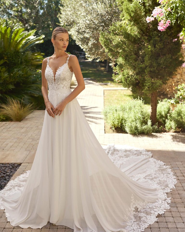 Vestido de novia línea A con escote profundo y tirantes. Cuerpo de encaje con pedrería, falda de georgette. Espalda en V con cremallera. ALMA_NOVIA.