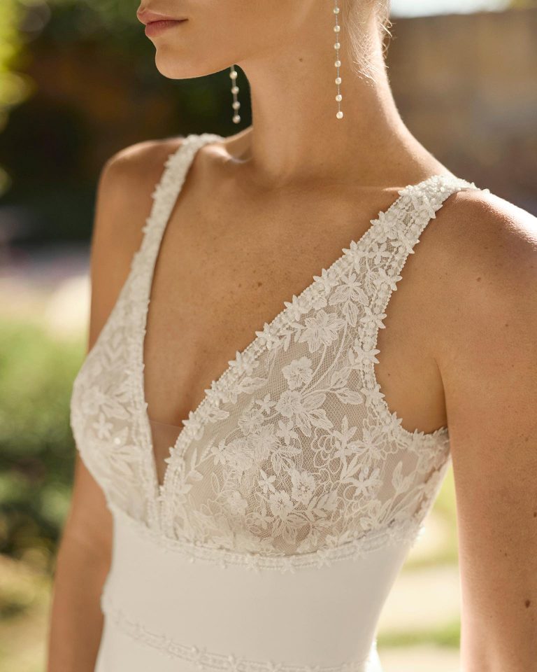 Vestido de novia de dos piezas con silueta línea A y talle imperio. Cuerpo de encaje con pedrería, escote pico, tirantes y espalda en V. Falda de crepé elástico. Incluye capa de georgette. ALMA_NOVIA.