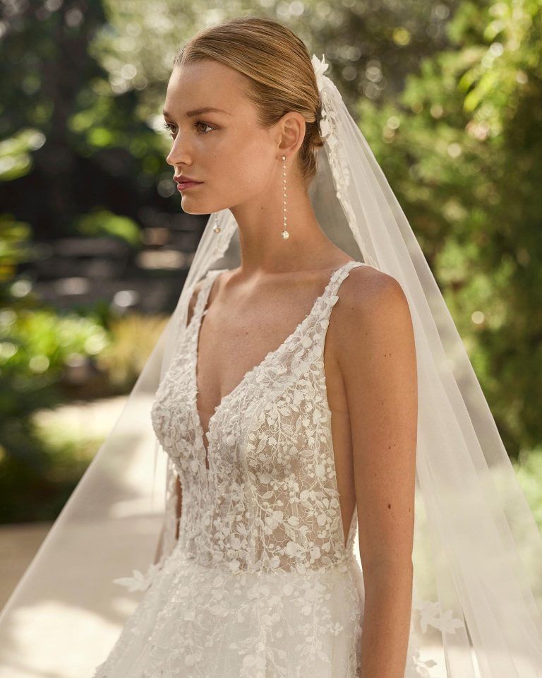 Vestido de novia línea A con escote pico, tirantes y espalda en V. Cuerpo de encaje con pedrería y falda de tul con aplicaciones. ALMA_NOVIA.