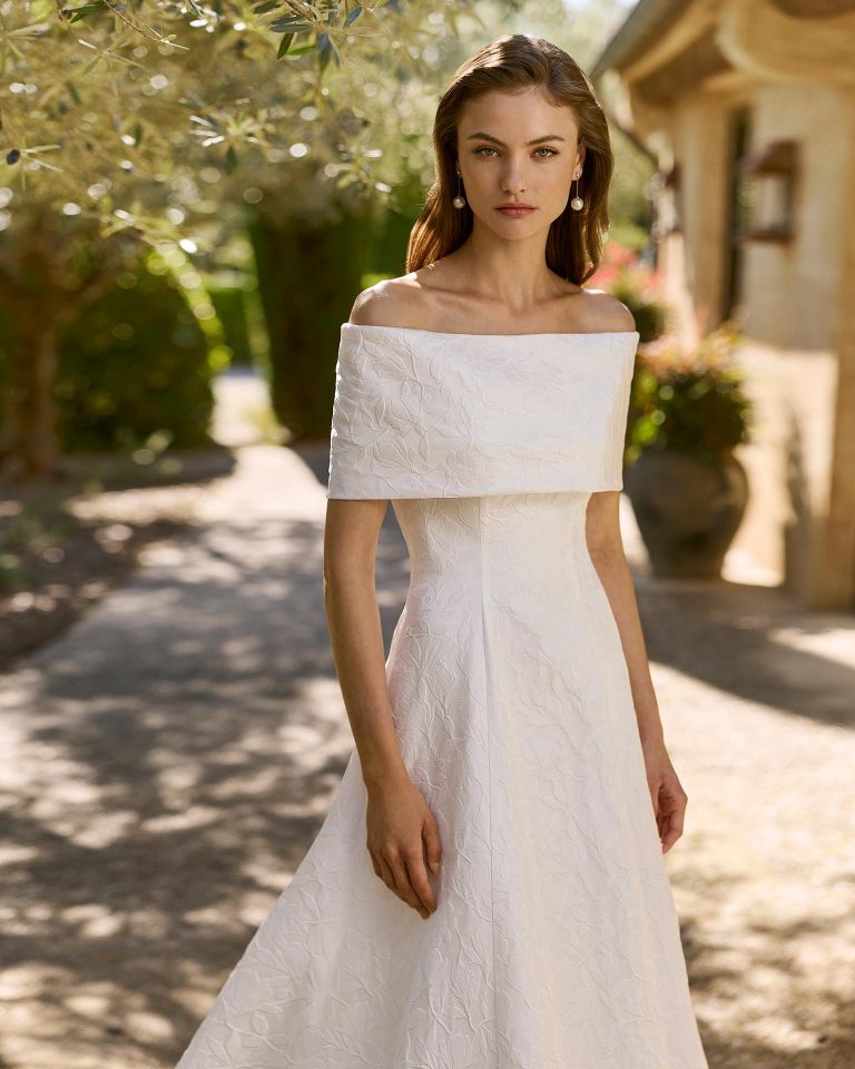 Vestido de novia de dos piezas en brocado gardenia con silueta línea A. Escote palabra de honor y cuello extraíble. Cierre con cremallera en espalda. ALMA_NOVIA.