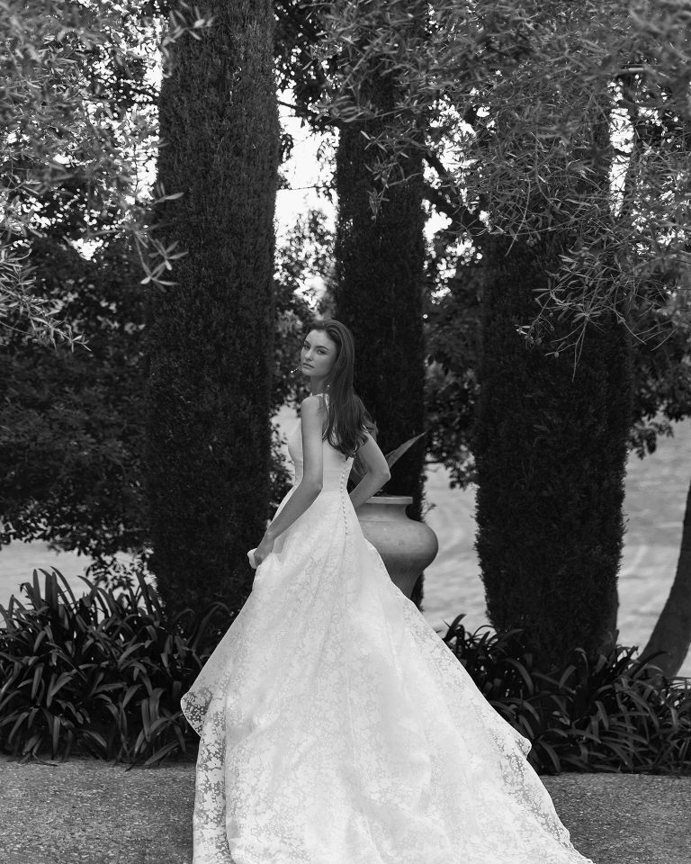 Vestido de novia en silueta línea A con escote profundo y espalda en V. Manga poeta larga en fil coupe. Cierre cremallera. ALMA_NOVIA.