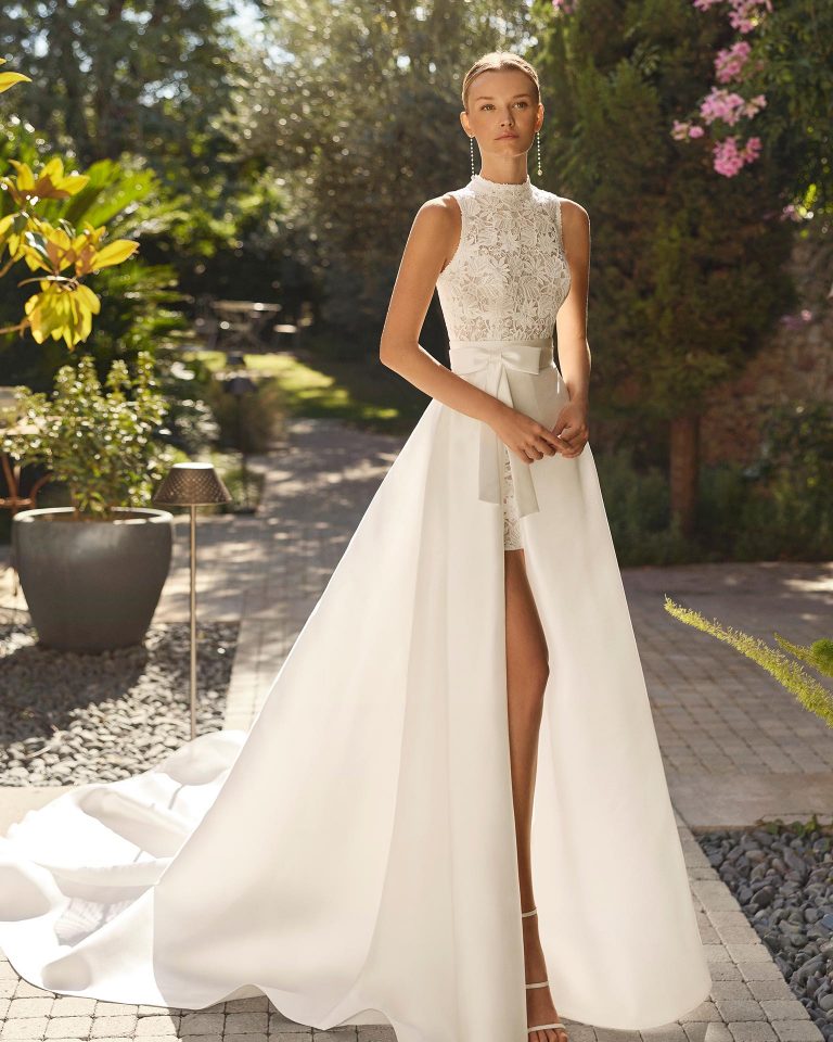 Vestido de novia corto de dos piezas con silueta recta. Cuerpo de encaje con escote caja y espalda con abertura. Cierre de cremallera. Sobrefalda de mikado verona. ALMA_NOVIA.