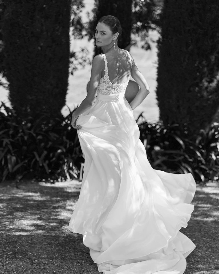 Vestido de novia línea A con escote cuadrado, cuerpo de encaje y pedreria y falda de georgette con abertura delantera. Mangas poeta en georgette y espalda con abertura redonda. ALMA_NOVIA.